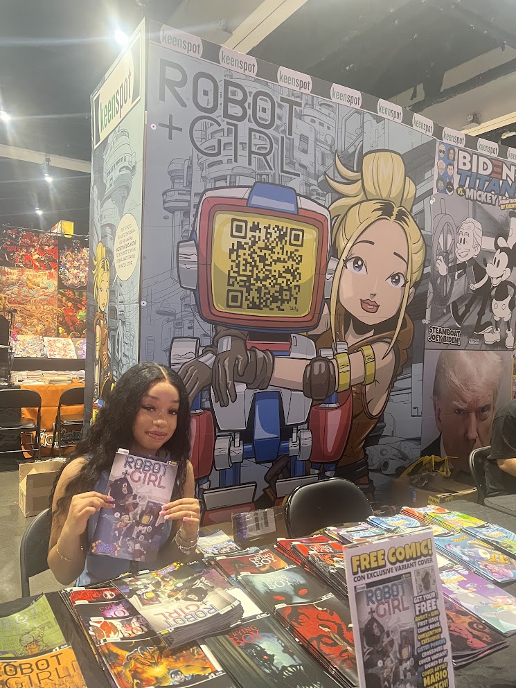keenspot display 2024, cute vendor holding a copy of robot and girl latest issue